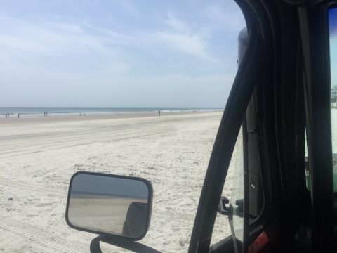 1989 Ford Bronco - Looking out at the ocean and sandy beach from the perspective of someone inside a vehicle.