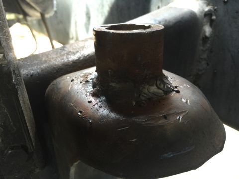 1989 Ford Bronco - A close-up shot shows a rusty metal bracket with a cylindrical tube welded to its top. The weld appears rough and unfinished, with visible…