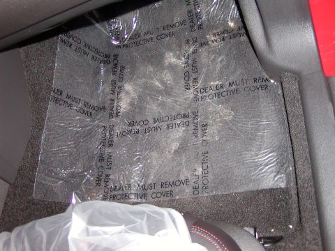 2007 Ford Mustang - The interior floor is covered with a protective plastic sheet that has text indicating it should be removed by the dealer.