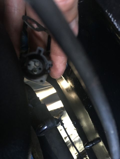 1989 Ford Bronco - A hand is holding a black electrical connector with three visible pins. The connector is attached to a wiring harness near a black hose.