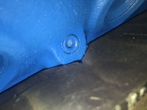 1989 Ford Bronco - A close-up view shows a blue painted metal component with a bolt head visible. The component appears to be part of a vehicle's undercarriag…