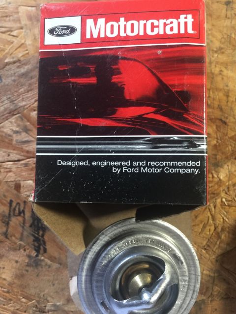 1989 Ford Bronco - A Motorcraft thermostat is shown in its original Ford packaging. The box is red and black with the Ford and Motorcraft logos visible.