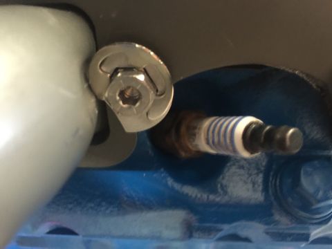 1989 Ford Bronco - Close-up of a spark plug and a bolt with a washer, likely in an engine bay.