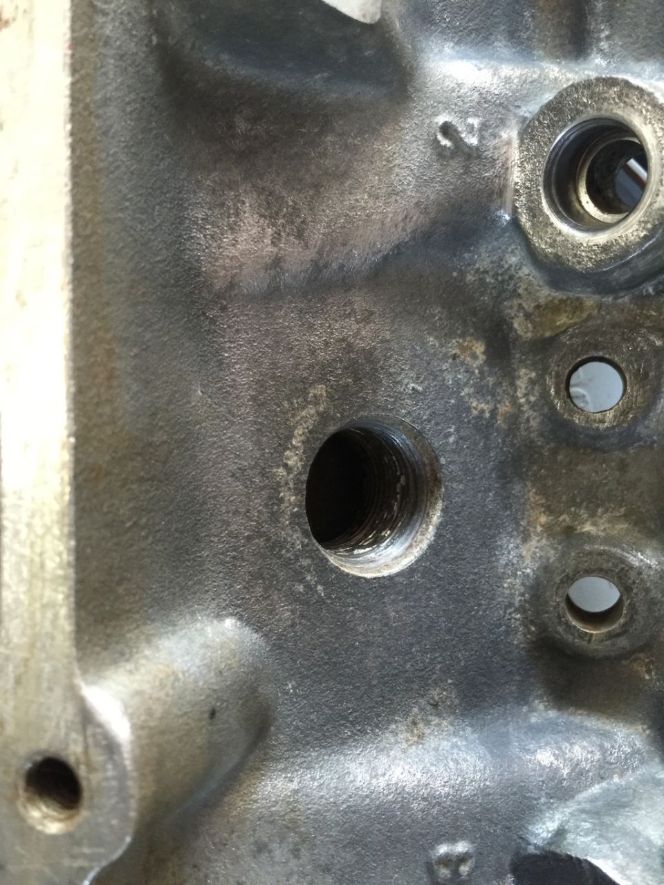 Close-up of a cast iron engine block with bolt holes and a number '2' cast into it