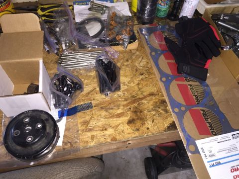 1989 Ford Bronco - Various engine components are organized on a wooden surface, suggesting a repair or upgrade project.