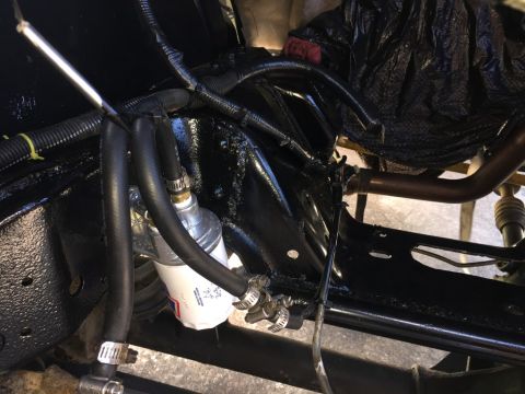 1989 Ford Bronco - Close-up view of a fuel filter installed in the engine bay, showing hoses and wiring.
