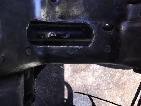1989 Ford Bronco - Close-up of a modified vehicle frame in the engine bay, showing a cut-out section.