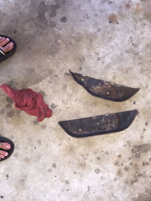 1989 Ford Bronco - Two old, weathered metal components lie on a stained concrete surface.