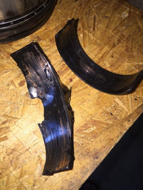 1989 Ford Bronco - These engine bearings show significant wear and damage, indicating a mechanical failure.