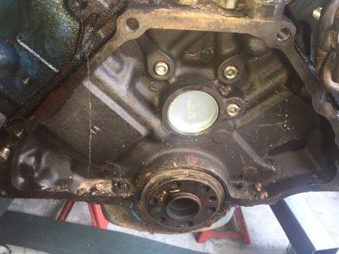 1989 Ford Bronco - Close-up view of an engine block, focusing on the crankshaft seal area and surrounding components.