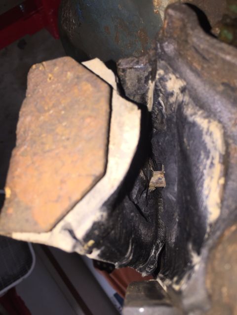 1989 Ford Bronco - Close-up view of a corroded engine part with visible metal and black casing.