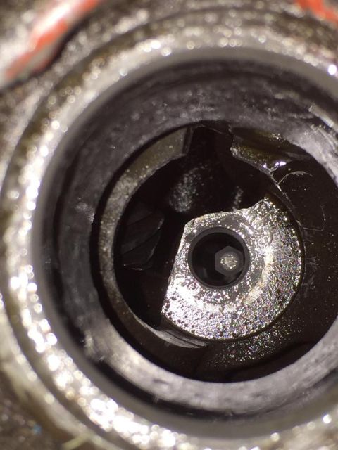 1989 Ford Bronco - A close-up view of a greasy engine component with a hexagonal bolt head visible.