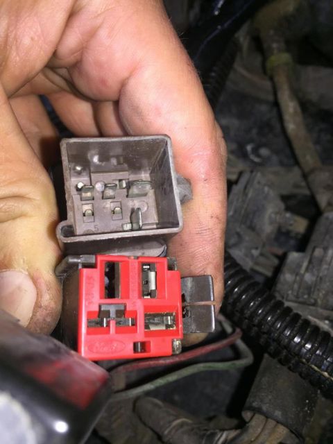 1989 Ford Bronco - Close-up of a hand holding a red Ford electrical connector and a gray connector, likely for relay replacement.