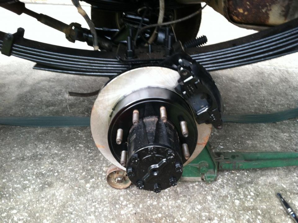 Rear brake assembly with black caliper and hub, leaf springs above