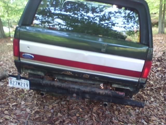 Rear view of a dark green Ford Bronco with a license plate 827M219
