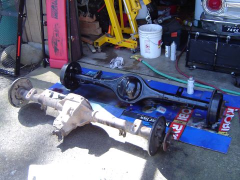 1989 Ford Bronco - Two differential assemblies are displayed outdoors, one appearing older and more worn than the other.