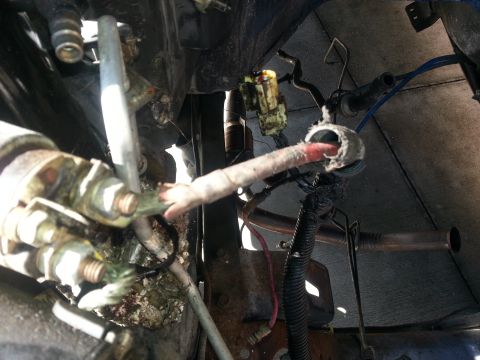 1994 Ford Bronco - Photograph of a vehicle's starter solenoid and battery cable connections under the body, not a diagram.