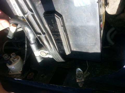 1994 Ford Bronco - Photograph of an installed automotive battery with cable terminal and label, not a vehicle data plate.