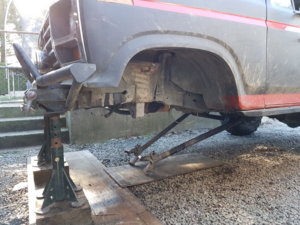 Front view of a dark Ford Bronco on jack stands with custom bumper