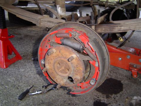 1989 Ford Bronco - Close-up of a vehicle's rear drum brake assembly, showing internal components and a red backing plate.