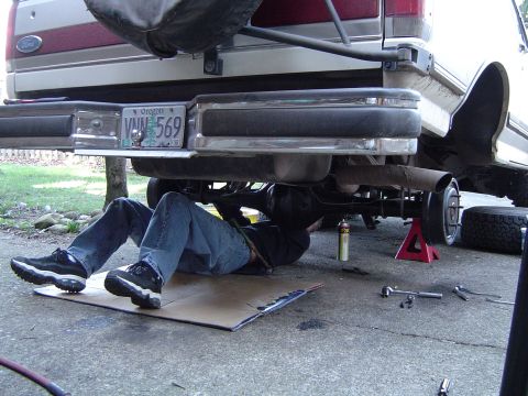1989 Ford Bronco - A person works on the rear axle and differential of a 1989 Ford Bronco.