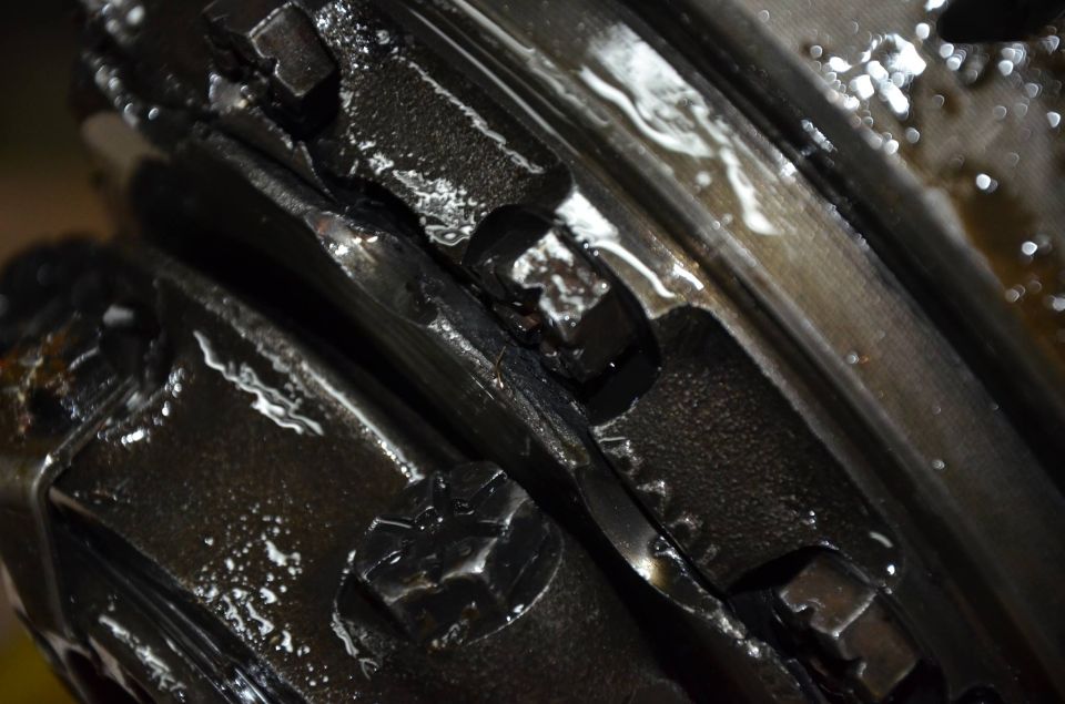 Close-up of lubricated gears in a differential, showing wear.
