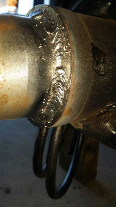 1984 Ford Bronco - A close-up view of a freshly welded metal joint on a vehicle's axle or suspension component. The weld shows distinct bead patterns and some…