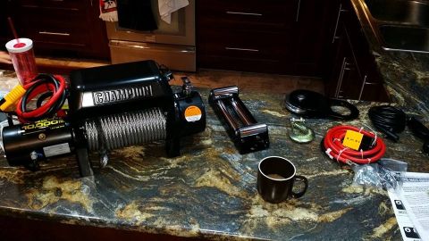 1984 Ford Bronco - A new Champion winch and its associated parts are laid out on a counter, ready for installation.