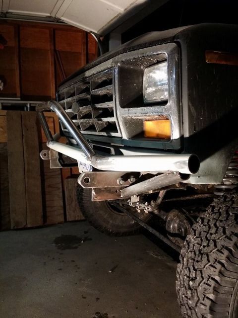 1984 Ford Bronco - A custom front bumper is being fabricated or installed on a dark green SUV, possibly a Ford Bronco from the early 1980s.