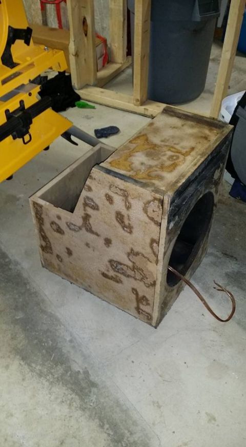 1984 Ford Bronco - A custom-built wooden subwoofer box with a circular opening and copper wiring is shown on a concrete floor. The box appears to be part of a…