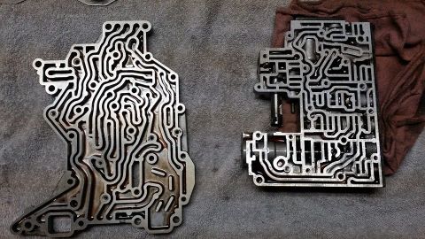 1984 Ford Bronco - Two transmission valve bodies, disassembled and laid out for inspection.