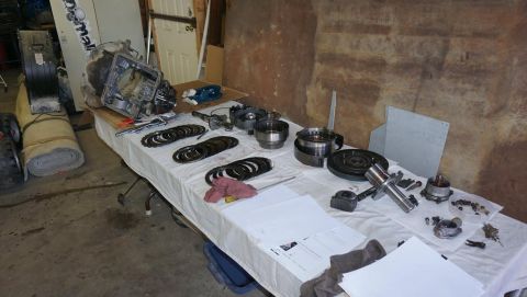 1984 Ford Bronco - Various transmission parts are spread across a table, suggesting a repair or rebuild process.