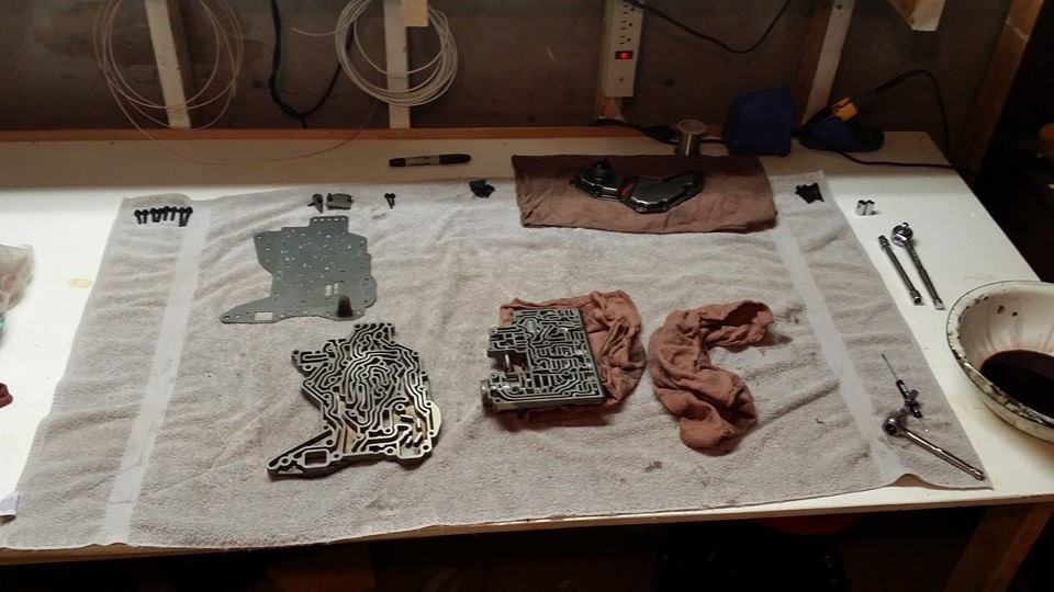 Transmission valve body and parts laid out on a towel with tools