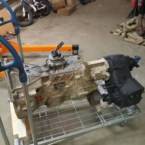 1984 Ford Bronco - Transmission and transfer case assembly shown on a cart in a garage setting.