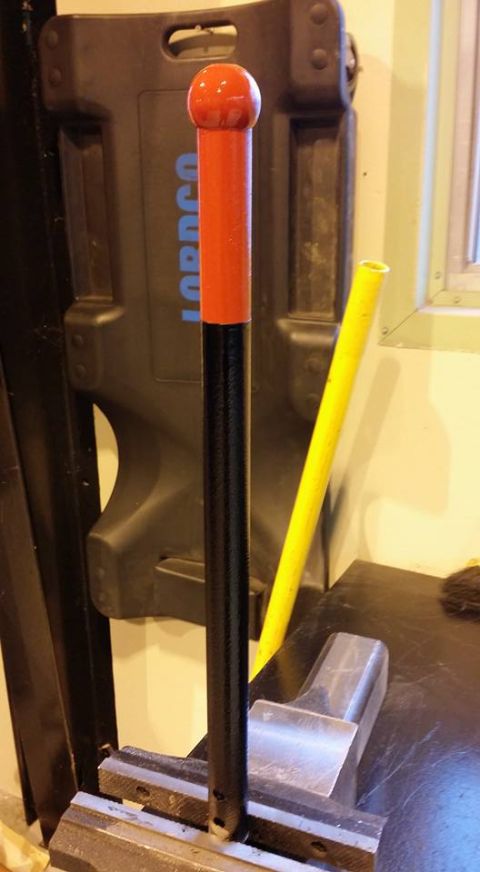 1984 Ford Bronco - Tool with a red ball handle clamped in a vise, with a yellow tube in the background.