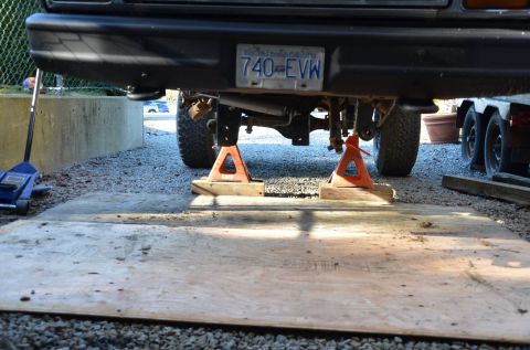 1984 Ford Bronco - Vehicle is raised on jack stands, showing the rear axle and suspension components.