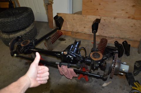 1984 Ford Bronco - A disassembled front axle assembly is laid out on the floor, with a hand giving a thumbs up.