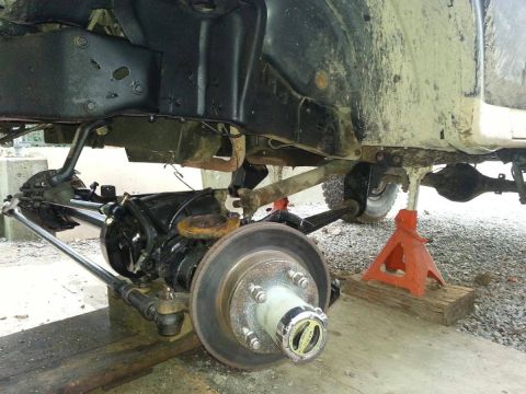1984 Ford Bronco - The front suspension and axle of a 1980s SUV are exposed for maintenance.
