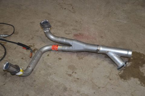 1984 Ford Bronco - A custom Y-pipe exhaust section is shown on a concrete floor, with welding equipment in the background.