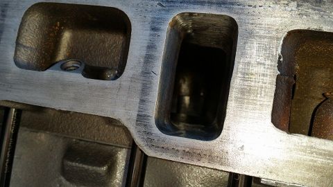 1984 Ford Bronco - Close-up view of an engine cylinder head, showing the ports for intake and exhaust valves.