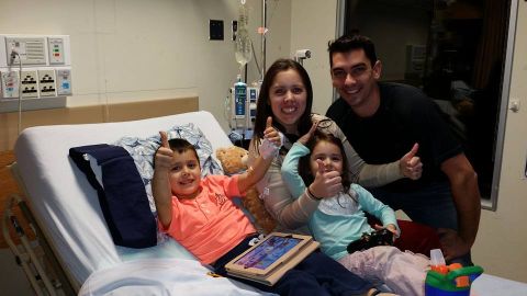 1984 Ford Bronco - A family celebrates with two children in a hospital room, all giving thumbs up.