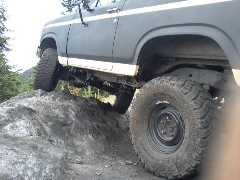 1984 Ford Bronco - This modified Ford Bronco is shown navigating a rocky trail, demonstrating its off-road capabilities.