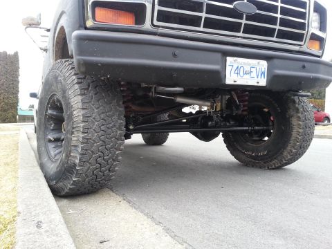 1984 Ford Bronco - This lifted truck features a prominent black grille and large off-road tires. The license plate is visible.