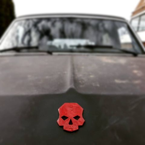 1984 Ford Bronco - A red skull emblem is affixed to the hood of a weathered vehicle.