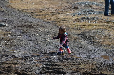 1984 Ford Bronco - A child interacts with a toy truck amidst a muddy outdoor environment.