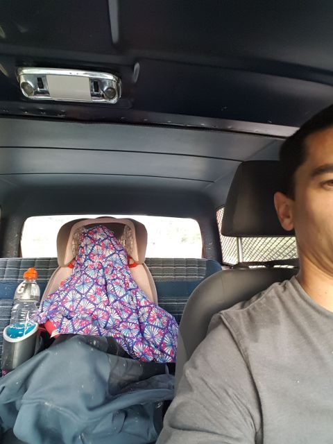1984 Ford Bronco - View from inside a vehicle, showing a child seat and a person.