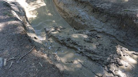 1984 Ford Bronco - Off-road trail conditions with deep mud and water, indicating challenging terrain.