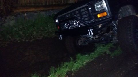 1984 Ford Bronco - Front view of a modified black off-road vehicle, likely from the 1980s, with a heavy-duty bumper and tow hooks.