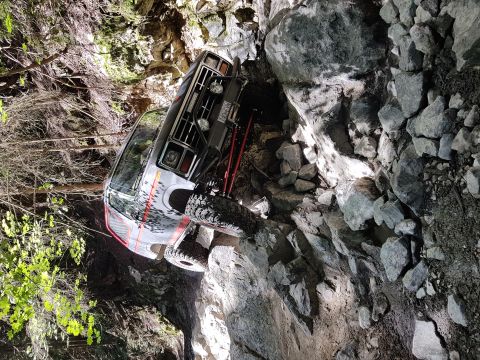 1984 Ford Bronco - This modified SUV is navigating a challenging, rocky off-road path with steep inclines.