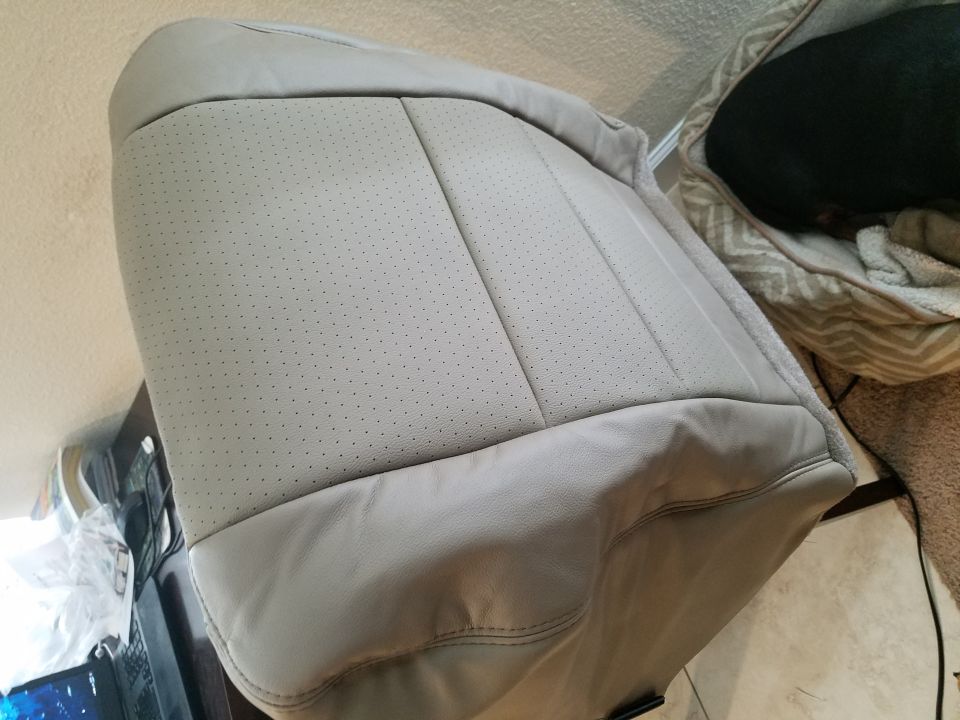 Light gray perforated leather car seat with stitching detail